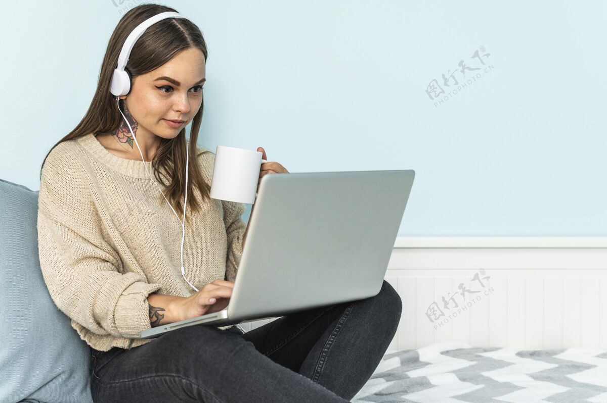 Ncov流感大流行期间 戴着耳机 使用笔记本电脑 在家喝咖啡的女人社会距离隔离咖啡