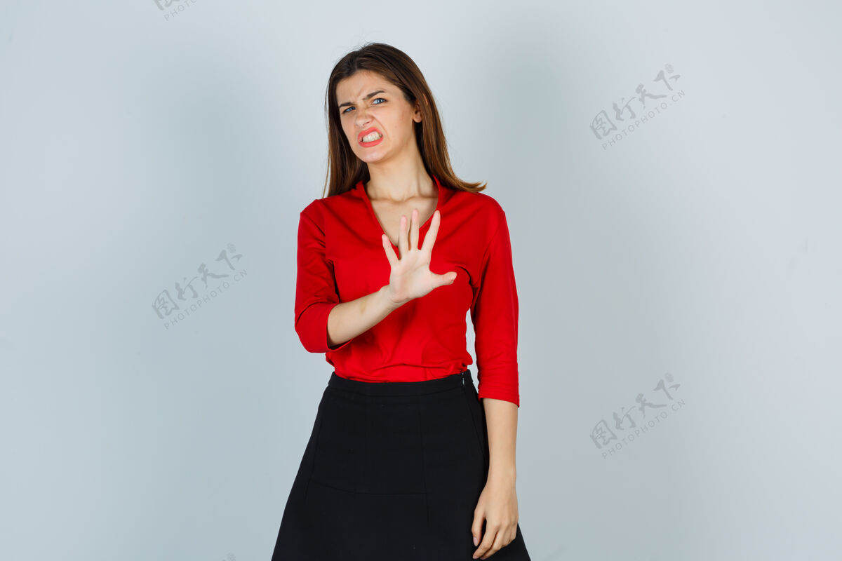 害怕穿红衬衫的年轻女士 裙子摆出一副止步的姿势 看上去很恶心手势不高兴成人
