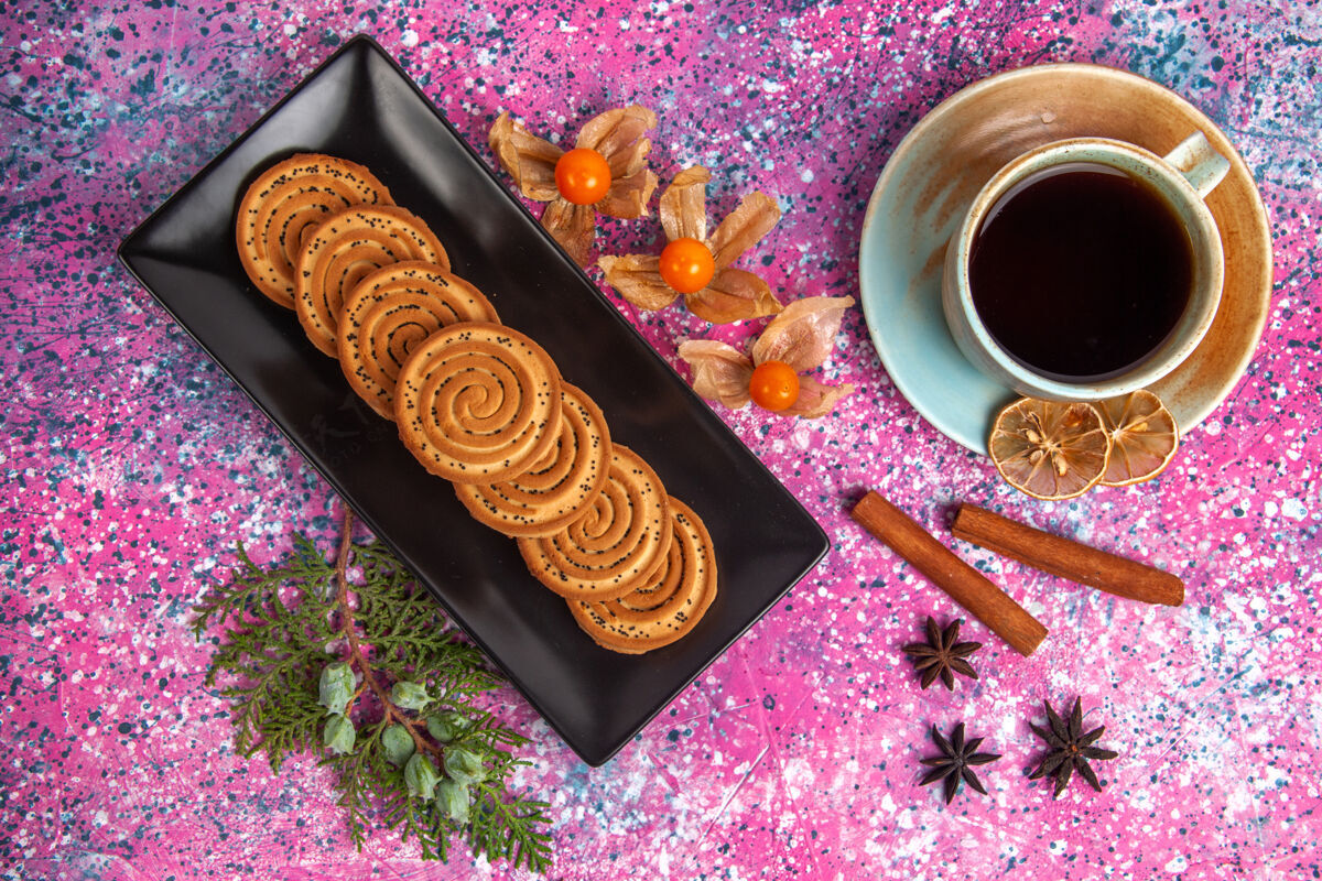 美味浅粉色表面上的桂皮甜饼和一杯茶的俯视图蛋糕饼干咖啡因