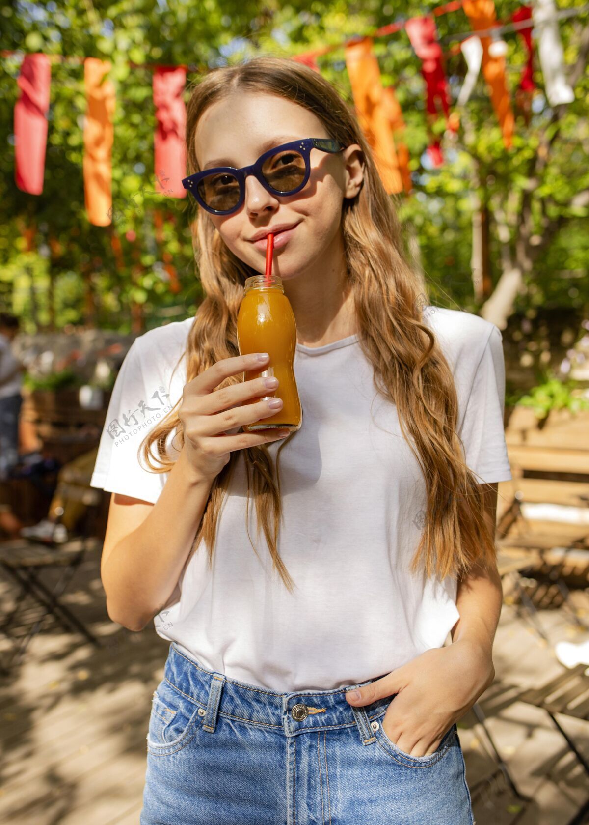 热带公园里拿着新鲜果汁瓶的女孩的画像果汁健康食品异国情调水果