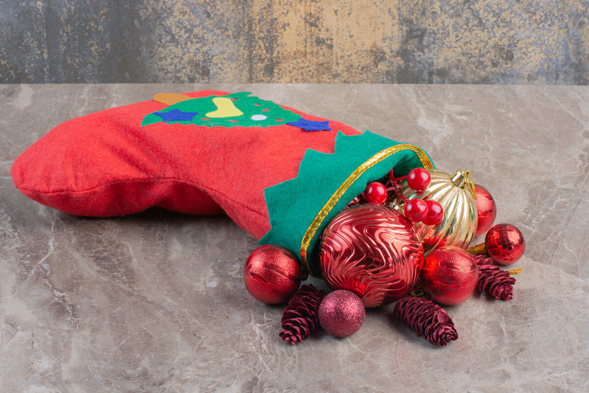 袜子一堆圣诞树装饰品和一只放在大理石上的圣诞袜子圣诞节传统树