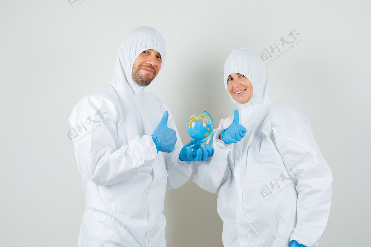 医疗两个医生拿着世界地球仪 穿着防护服竖起大拇指年轻实验室站