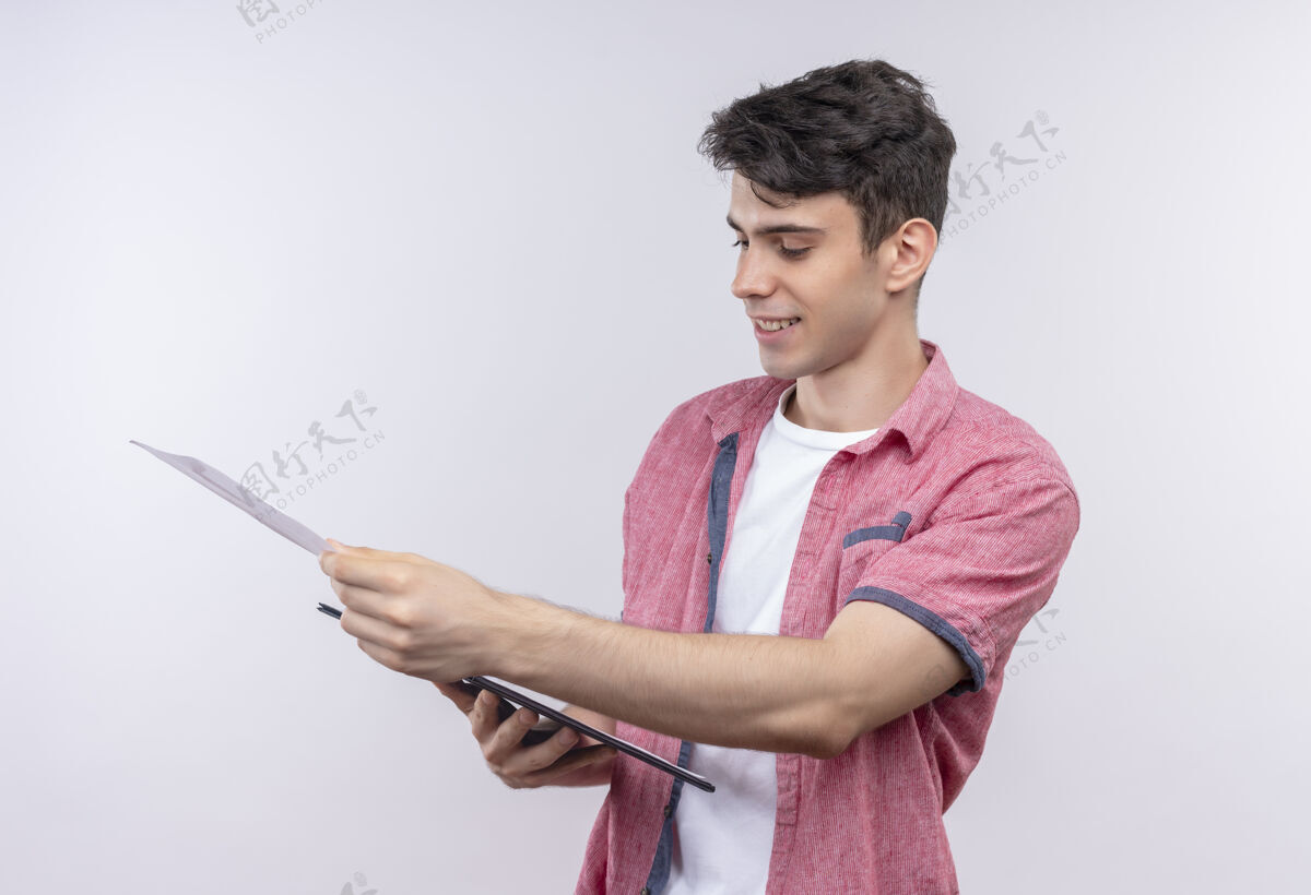 家伙带着微笑的白人年轻人穿着粉色衬衫 在孤立的白色背景上翻着剪贴板翻动粉色年轻