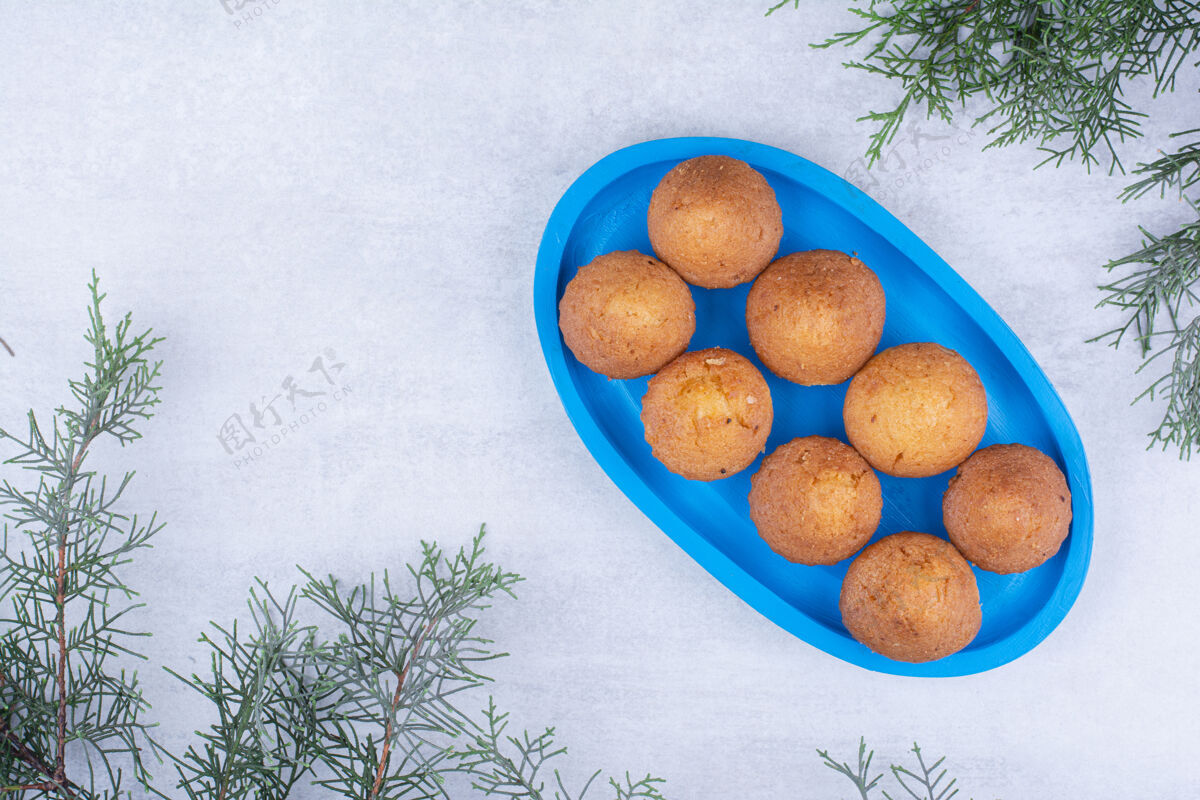 圣诞节松枝蓝盘子上的美味小饼饼干松树枝蛋糕