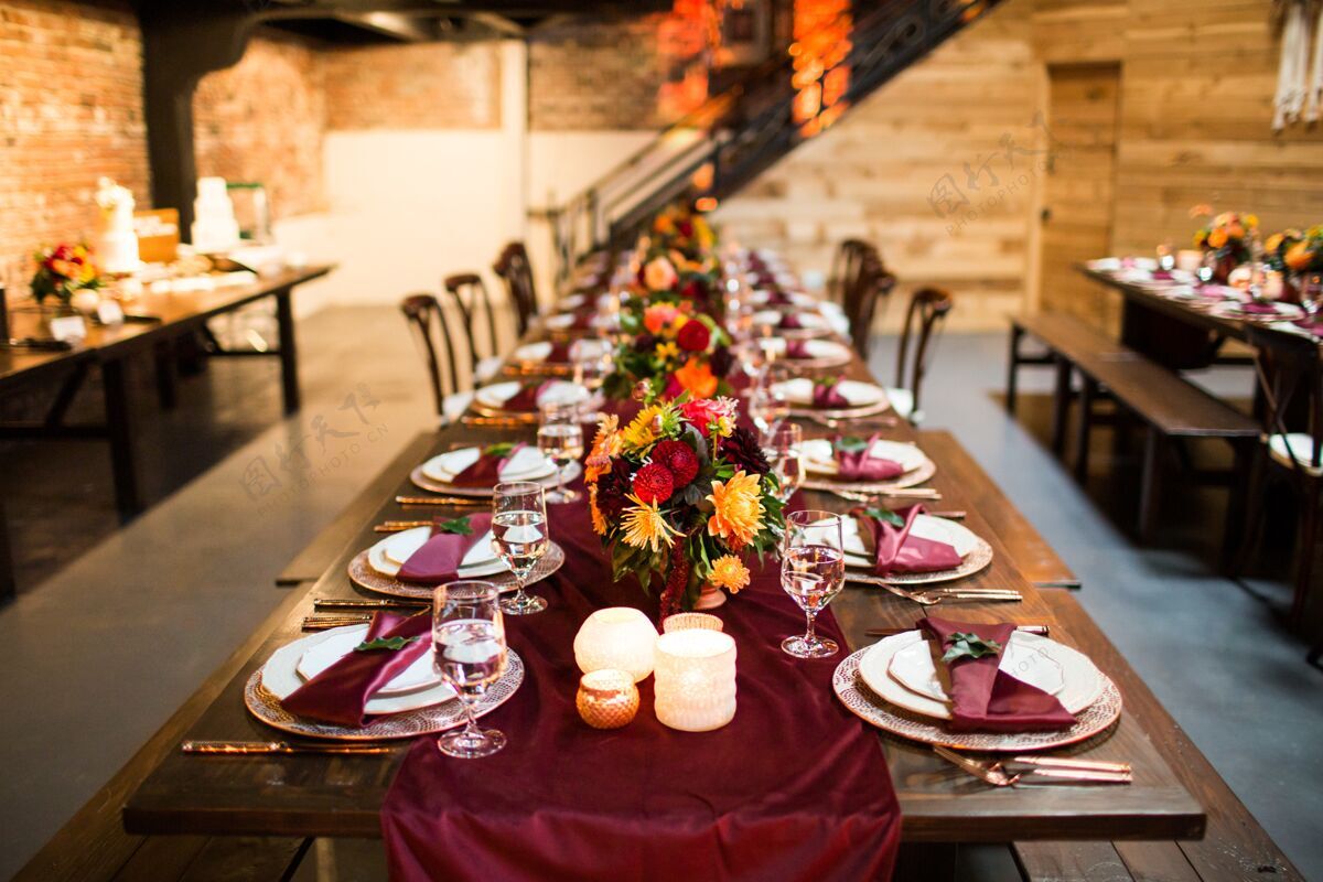 庆典长桌上摆着豪华的盘子 装饰着五颜六色的鲜花和蜡烛活动花卉风格
