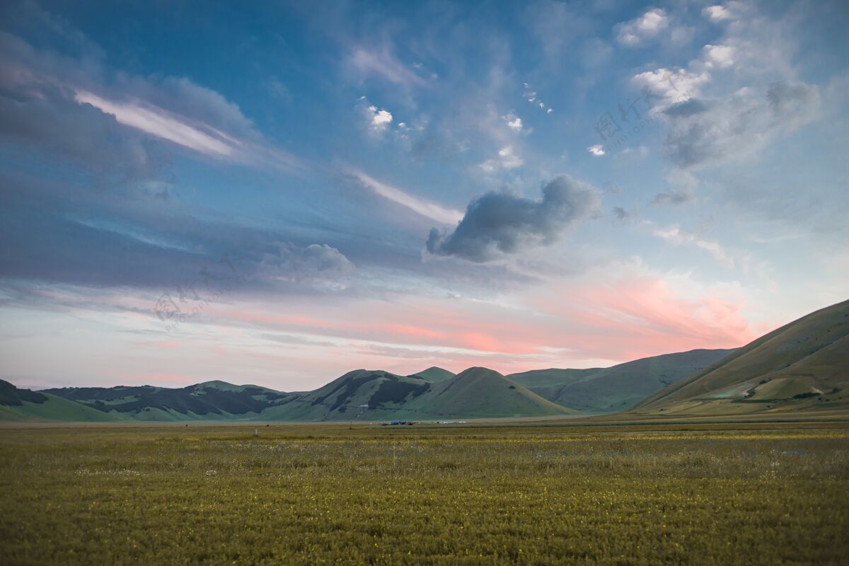 农业在意大利五彩缤纷的多云天空下 草地上美丽的绿色山脉的广角镜头乡村明亮天空