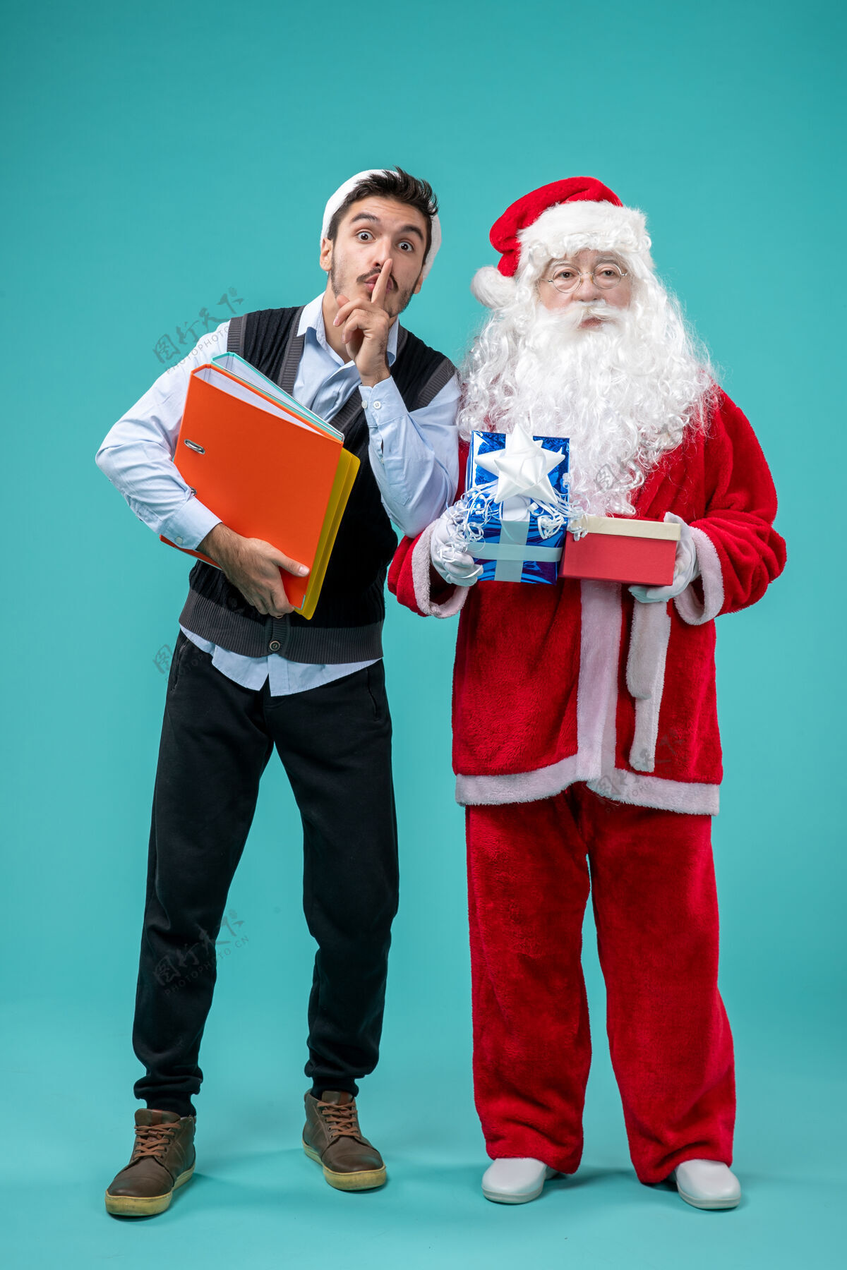 圣诞前视图圣诞老人与年轻的男性和礼物上的蓝色背景年轻视图微笑