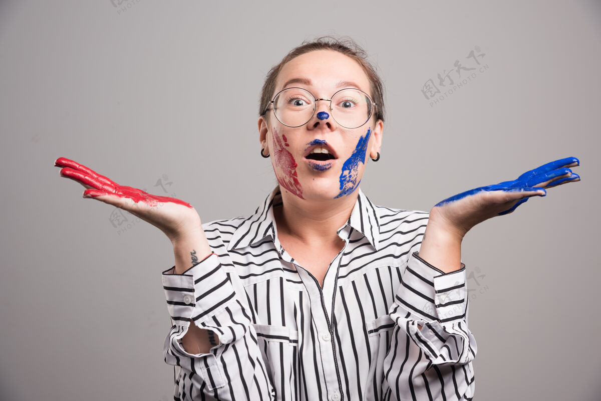 艺术家在灰色背景上 一个女人在脸上摆着颜料高质量的照片人乐趣眼镜