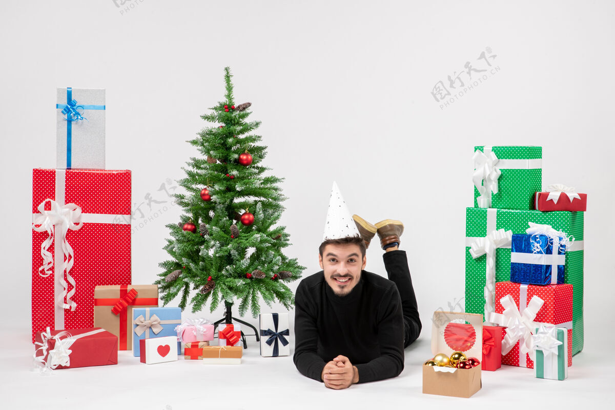 模型正面图：年轻人正快乐地躺在白色墙上的节日礼物周围礼物前面墙板