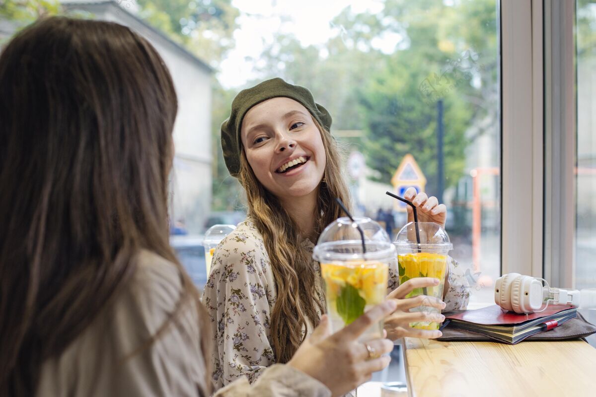 异国情调水果喝着新鲜饮料的女人在咖啡馆里聊天健康食品水果食品