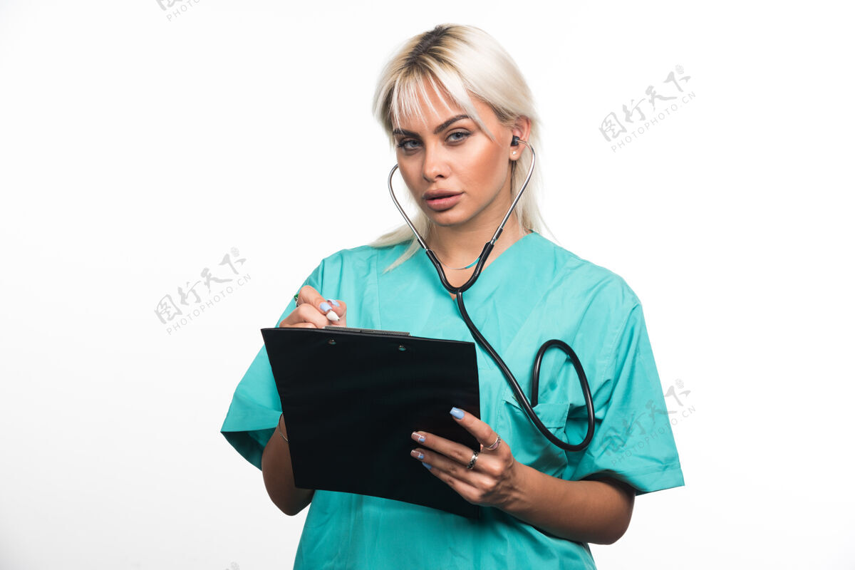 人类女医生在白色背景的剪贴板上写东西高质量的照片站文件工作