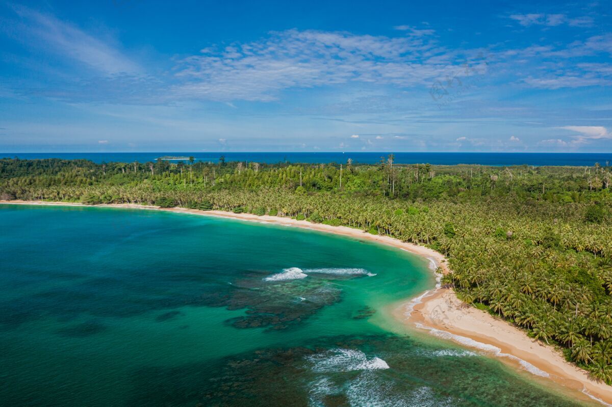 景观鸟瞰一个美丽的热带海滩与白色沙滩和绿松石碧水在印度尼西亚树海洋海景