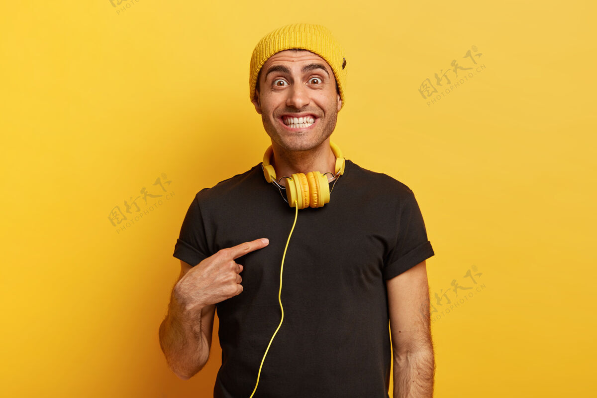 反应开朗的白种人黑眼睛的男人高兴地指着自己 很高兴有好的建议 穿着黑色t恤水平搞笑耳机