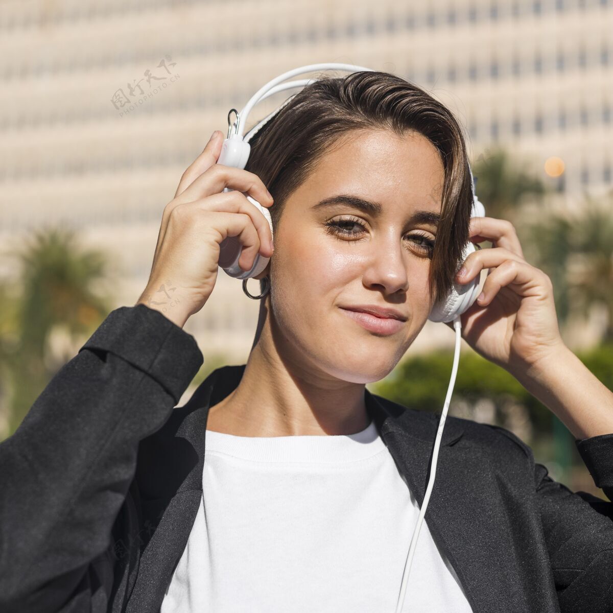 现代女人在户外用耳机听音乐人女人休闲