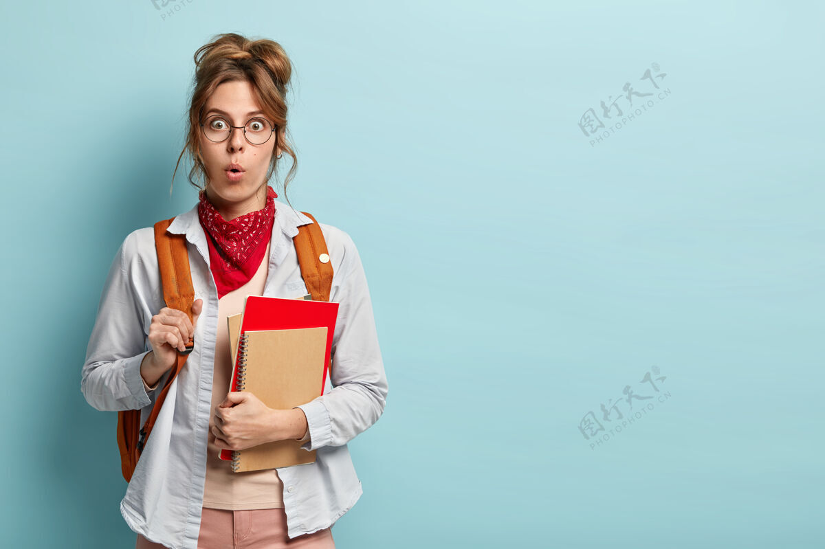 印象印象深刻的惊呆了的学生参加语言课程 拿着笔记本 戴着眼镜 红色的手帕和衬衫青少年文案女性