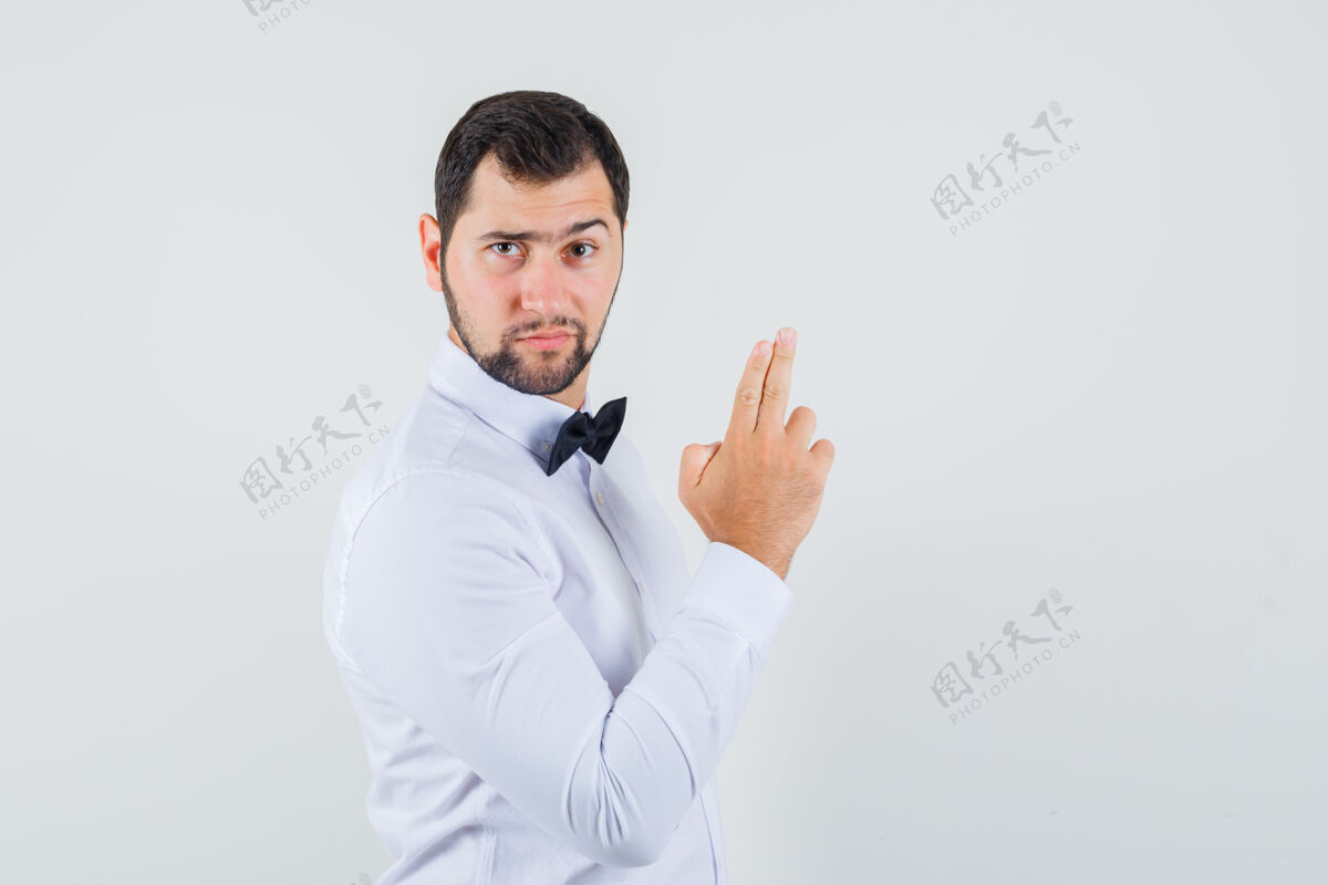 工人穿着白衬衫的年轻服务员正在做手指的招牌 看上去很自信 正面照酒吧休闲女性