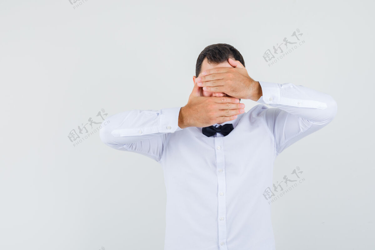 人年轻的男性手牵着眼睛和嘴在白衬衫前视图时尚休闲成人