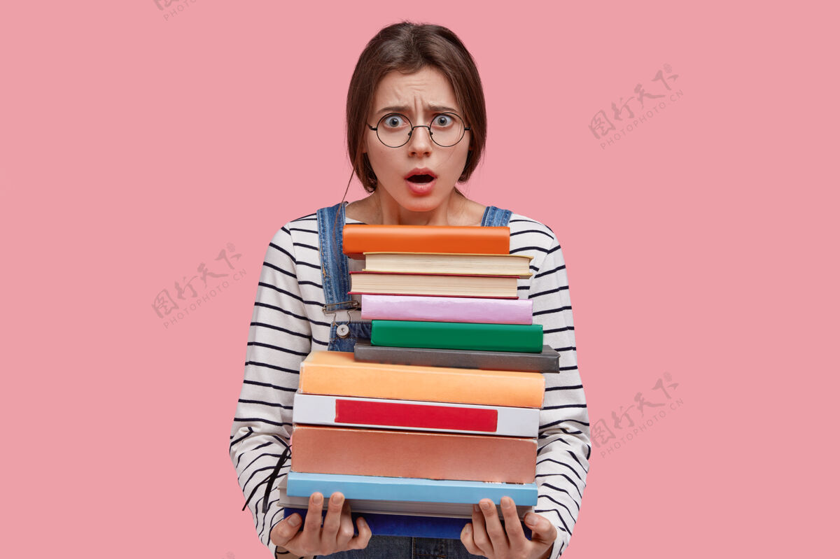 眼镜愤怒小姐的照片让人目瞪口呆 戴着圆眼镜 手里拿着一大堆书学生可怕厌恶