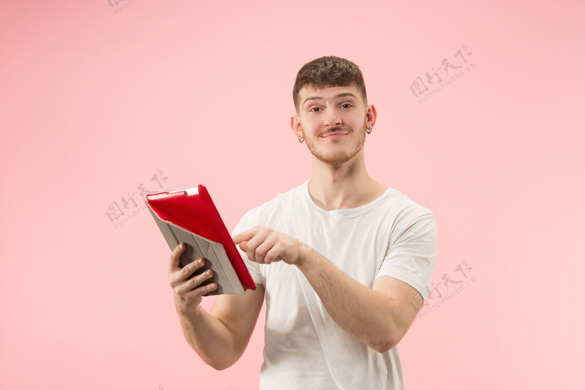 男性粉红色工作室里 一个微笑的男人指着笔记本电脑 空白屏幕被孤立网络笔记本电脑电脑