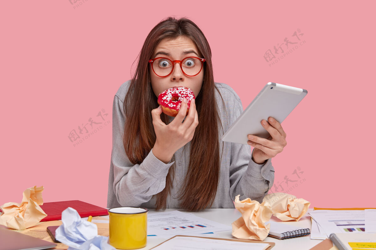 可怕害怕情绪化的女人 眼睛被 喜欢吃美味的甜甜圈 害怕因为糟糕的工作受到惩罚 携带现代触摸板可怕眼镜互联网