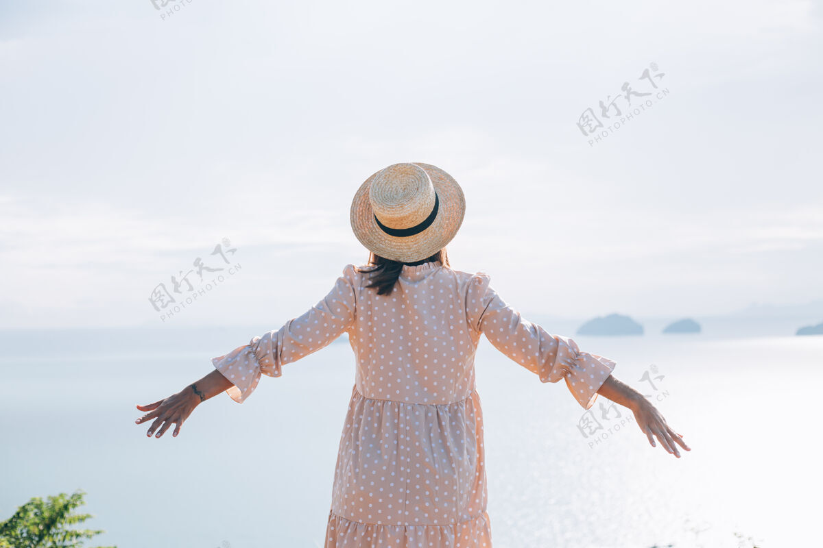 放松快乐的女人在夏天可爱的裙子和草帽度假与热带异国情调的看法热带自然快乐