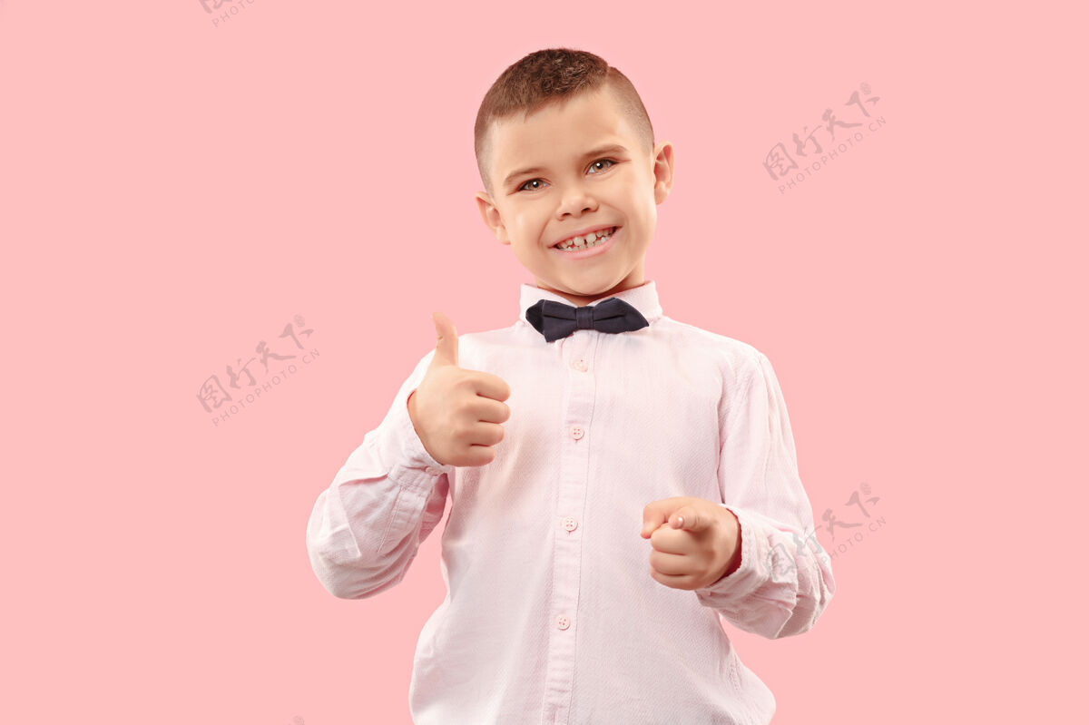 开朗快乐的少年男孩微笑孤立在粉红色的工作室男孩欢呼胜利