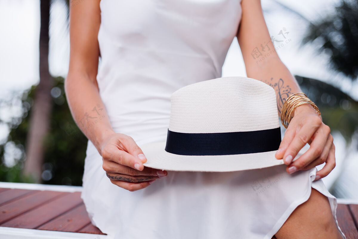 经典穿着丝绸合身连衣裙 戴着经典白帽子的近景女郎时尚优雅隐藏