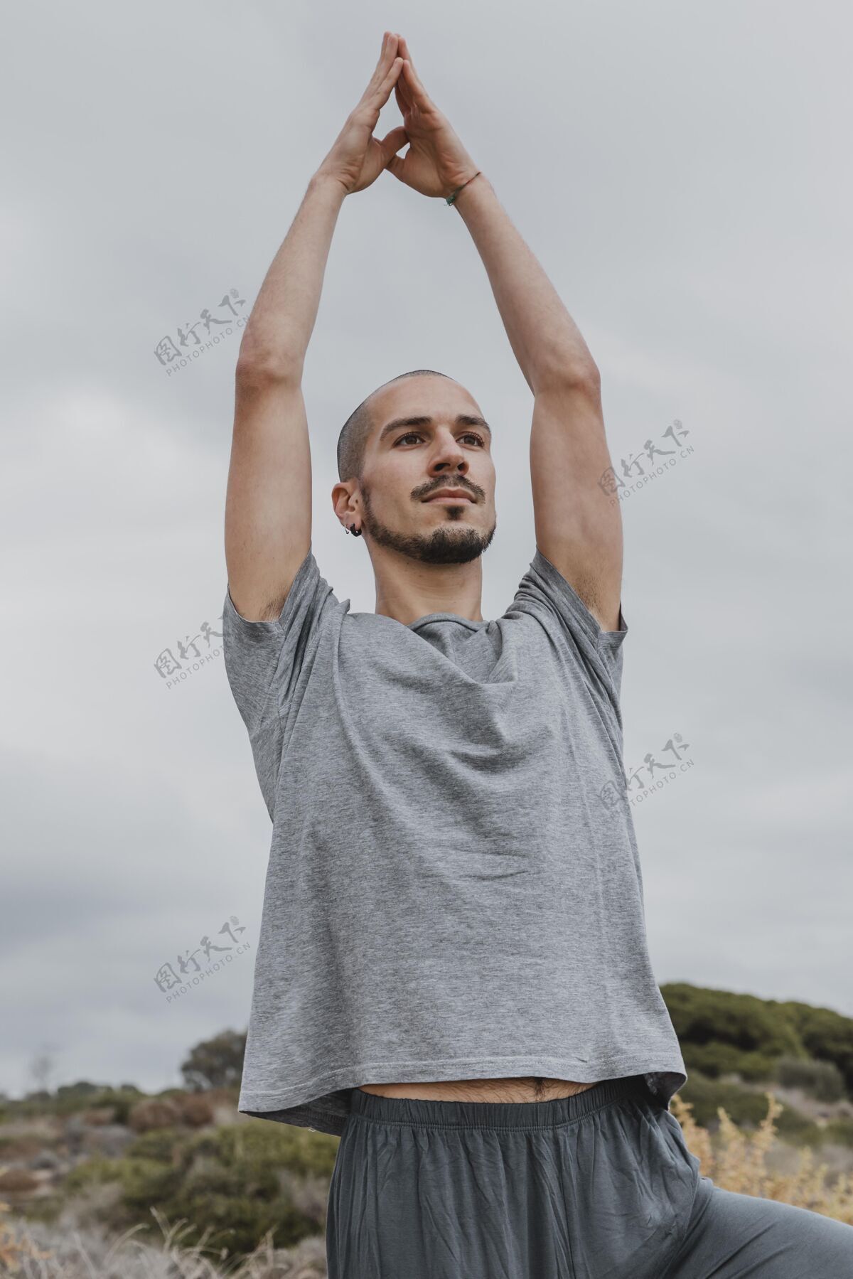 垂直男人在户外做瑜伽时举起手臂户外男性禅宗